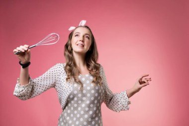 Elinde çırpı olan genç, çekici pasta şefi kadın..