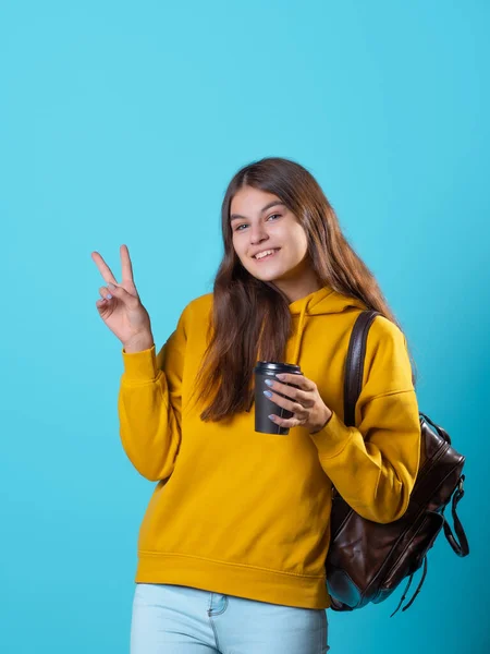 Ładna młoda brunetka w dżinsach i żółtej bluzie. Piękny student. — Zdjęcie stockowe