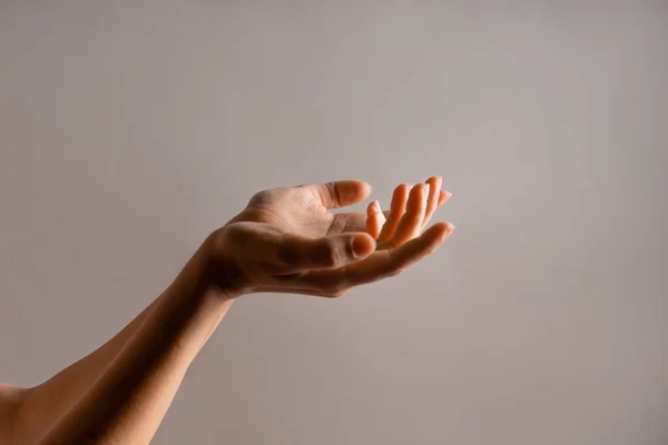 Elegáns női kéz, oldalt mutatva. Palm tart valamit, egy üres a design. Kézmozdulatok — Stock Fotó
