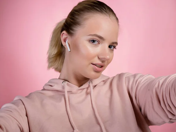 A young charming blonde takes a selfie, a view from the camera. Stock Image