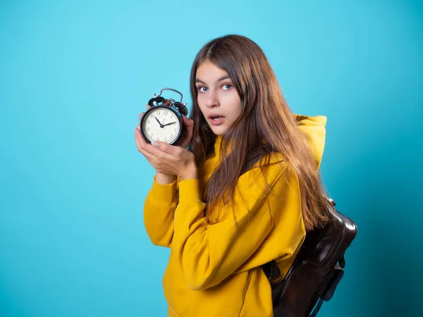 Dépêche-toi, concept. Une jeune brune dans un sweat à capuche de jeunesse tient un réveil — Photo