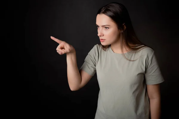 To be indignant and accuse the interlocutor, a young woman argues with the interlocutor by pointing her finger. - Stock-foto