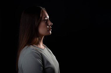 Profilde genç bir esmerin sakin portresi, ileriye bakıyor. Contour ışığı, sağdaki boşluğu kopyala,