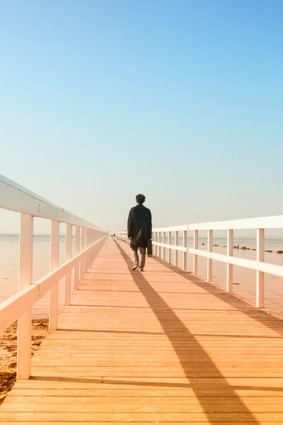 L'uomo sul ponte che cammina verso il mare — Foto Stock