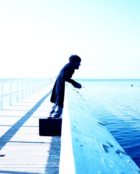 Hombre en el puente caminando en el mar — Foto de Stock