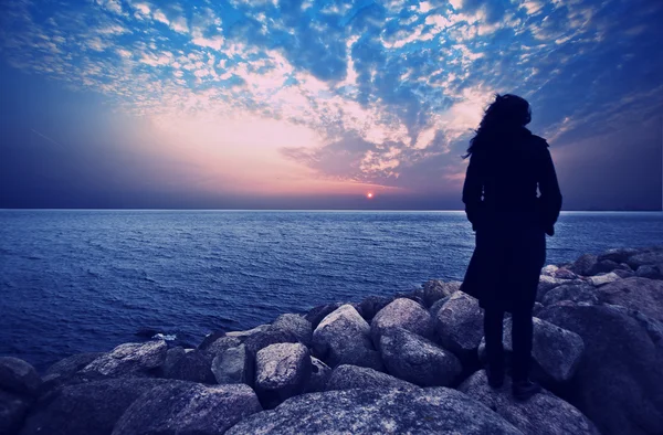 Mujer de pie en la sombra en la hermosa puesta de sol — Foto de Stock