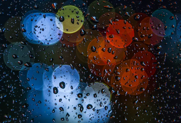 Wazig licht met regen druppels op het venster — Stockfoto
