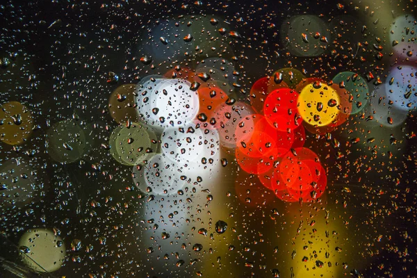 Luz borrosa con gotas de lluvia en la ventana —  Fotos de Stock