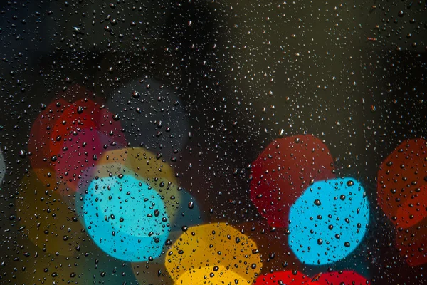 Luz borrosa con gotas de lluvia en la ventana —  Fotos de Stock