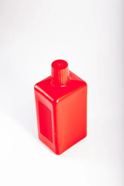 Frasco de plástico vermelho no fundo branco — Fotografia de Stock