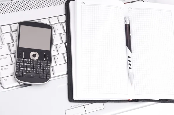 Bedrijf. telefoon en notepad op laptop. — Stockfoto