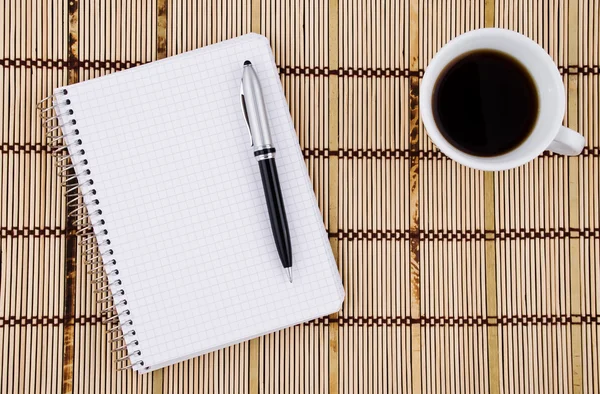 Bloco de notas, caneta e caneca de café . — Fotografia de Stock