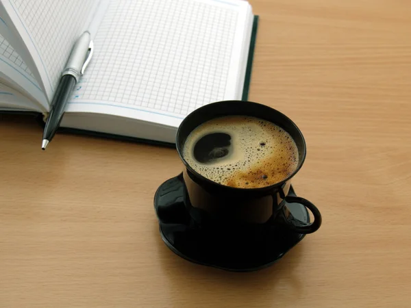 Filiżankę kawy i notatnik — Zdjęcie stockowe