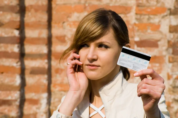 Girl with credit card and mobile phone Stock Picture