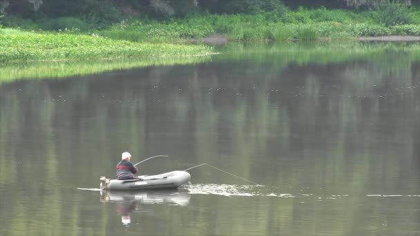 Hombre pescando en el lago — Vídeos de Stock