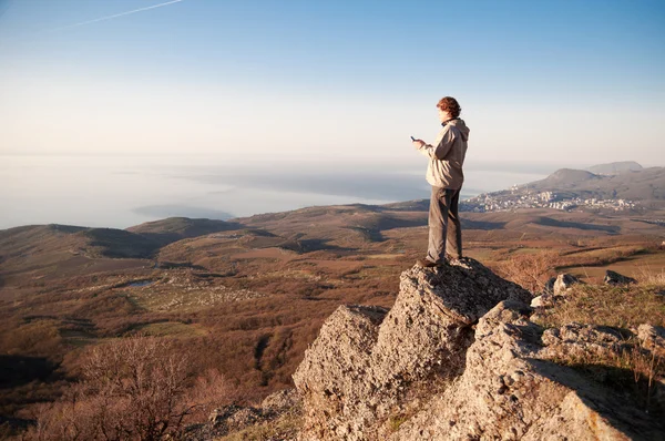 Людина з мобільним телефоном на вершині світу — стокове фото