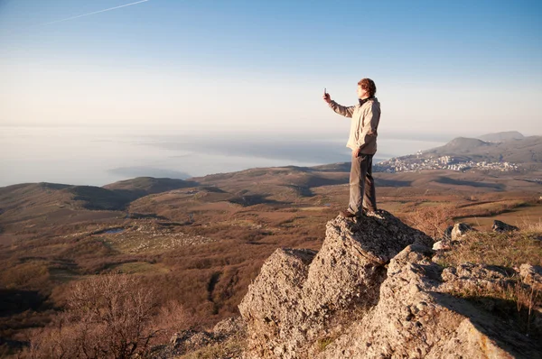 Человек с мобильным телефоном на вершине мира — стоковое фото