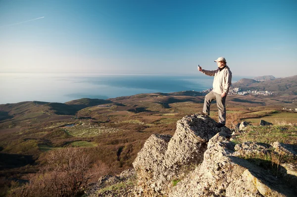 Hombre con teléfono móvil en la cima del mundo —  Fotos de Stock