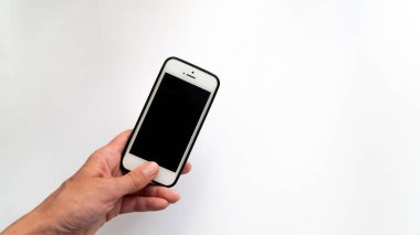 Kadın sol yakın plan, beyaz arkaplanda bir yazı için siyah ekranlı bir telefon tutuyor.