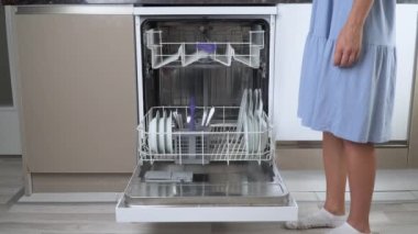 Bir ev hanımı bulaşık makinesine kirli bulaşık doldurur. Yüksek kalite 4k görüntü