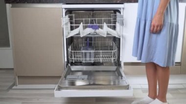 Bir kadın bulaşıkları yıkadıktan sonra bulaşık makinesinin üst rafını boşaltır. Yüksek kalite 4k görüntü