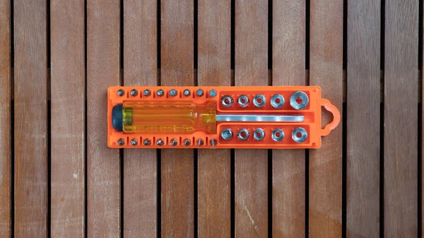 Ahşap bir arka planda plastik bir kutuda parçaları olan tornavida. Yüksek kalite fotoğraf