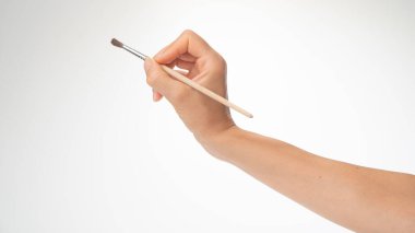 Bir kadının sağ elinde fırça çizmek, beyaz bir arkaplana resim çizmek. Yüksek kalite fotoğraf