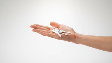 Beyaz arka planda bir avuç anahtar bir kadının avucunda yatıyor. Yüksek kalite fotoğraf