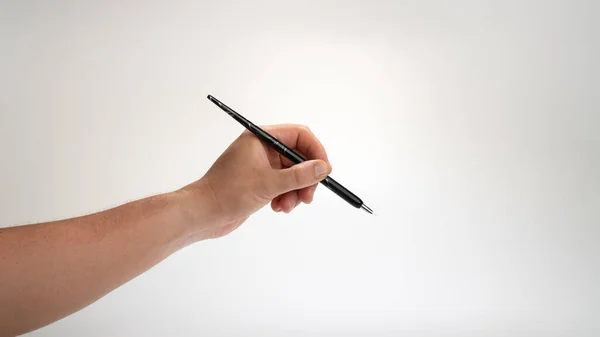 Mannen Linkerhand Houdt Een Kalligrafie Pen Een Witte Achtergrond Gebaar — Stockfoto