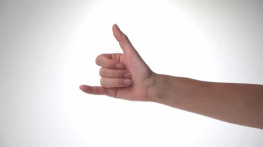 Bir kadın eli, sörfçülerin selamını, baş parmağını ve küçük parmağını dışarı çıkaran Shaka 'yı gösterir. Yüksek kalite 4k görüntü