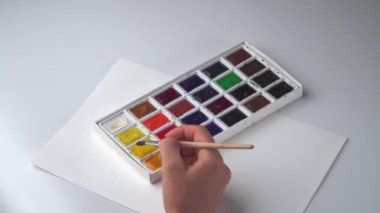 Kadın eli çizim fırçası ve peyzaj kağıdında suluboya ile beyaz arka plan. Yüksek kalite 4k görüntü