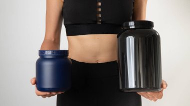 Spor üniformalı bir kadın elinde bir kutu protein ve bcaa tutuyor. Yüksek kalite fotoğraf