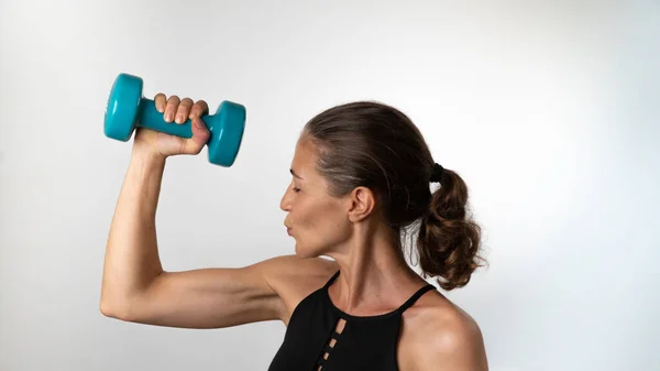 Uma Mulher Beija Bíceps Depois Treino Desportivo Com Halteres Nas — Fotografia de Stock