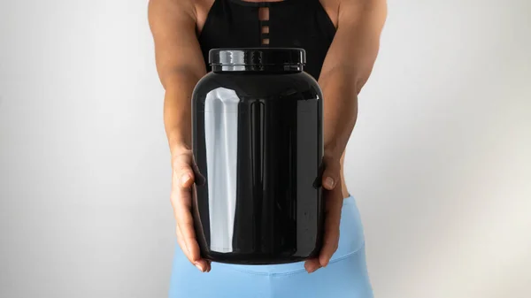 Kadınların elinde büyük bir spor konservesi var. Eğitim için yararlı malzemeler. Yüksek kalite fotoğraf