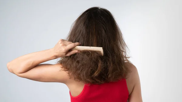 Une Femme Essaie Peigner Ses Cheveux Emmêlés Par Derrière Avec — Photo