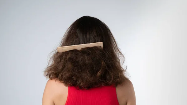 Comb stuck in a womans matted hair, scratching problems. High quality photo