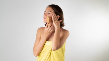 Bir kadının yüzüne masaj fırçası. Evde yüz bakımı. Yüksek kalite fotoğraf