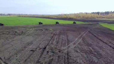 ATV 'ler toprak ve yeşil çim manzaralı bir alanda dört nala ilerliyorlar. Yüksek kaliteli FullHD görüntüler