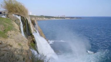 Şelalenin güçlü fıskiyeleri bir su girdabıyla denize akıyor. Yüksek kaliteli FullHD görüntüler