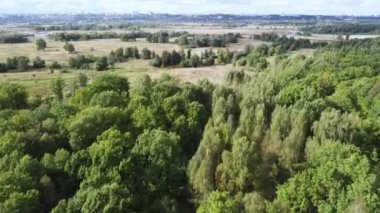 Ormanların üzerinden şehrin arka planına doğru uçmak, bir kuadkopterden havadan fotoğraf çekmek. Yüksek kaliteli FullHD görüntüler