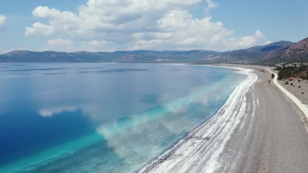 Quadcopter Let Mezi Modrou Vodou Bílou Pláží Pozadí Hor Vysoce — Stock video