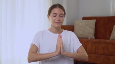 Bir kadın meditasyon yapıyor, avuçları göğsünün önünde namaste 'de. Yüksek kalite 4k görüntü