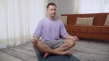 Nilüfer pozisyonunda bir adam evde meditasyon yapar. Yüksek kalite 4k görüntü