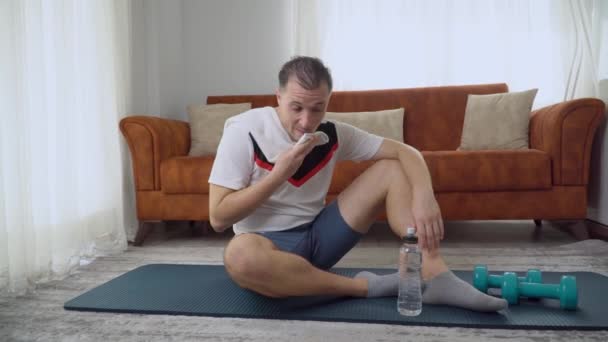 Ένας Άνθρωπος Πίνει Νερό Μετά Από Μια Προπόνηση Στο Σπίτι — Αρχείο Βίντεο