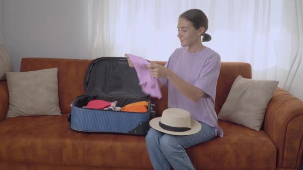 Mujer Empaca Ropa Una Maleta Sentada Sofá Preparándose Para Viaje — Vídeos de Stock