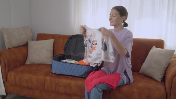Flicka Packar Resväska För Semester Ett Varmt Land Viker Kläder — Stockvideo
