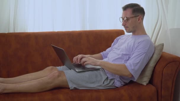 Muž Brýlemi Pracuje Laptopu Který Sedí Gauči Domova Pracuje Dálku — Stock video