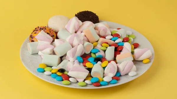 Teller Mit Süßigkeiten Auf Gelbem Hintergrund Hochwertiges Foto — Stockfoto