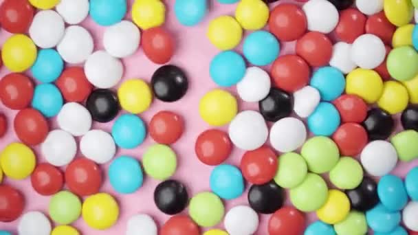 Los Dragees Caramelo Multicolor Mueven Temblando Sobre Fondo Rosa Movimiento — Vídeos de Stock