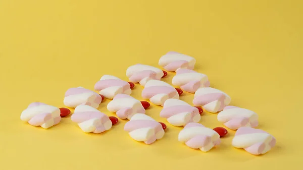 Marshmallows Und Rote Zuckerdragees Form Eines Dreiecks Auf Gelbem Hintergrund — Stockfoto